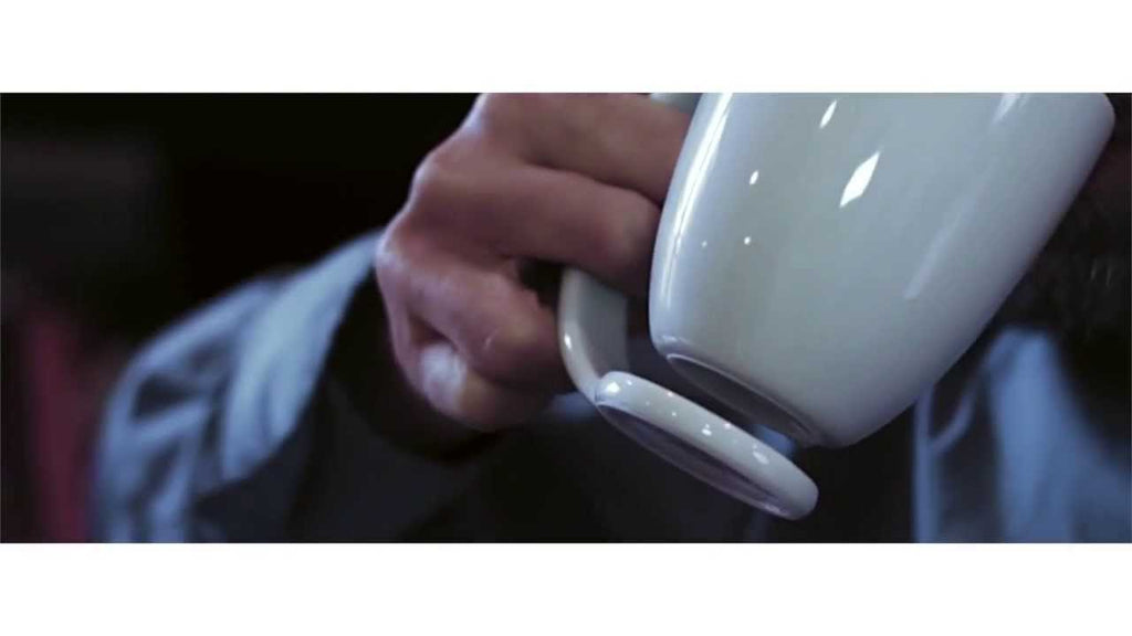 A porcelain mug integrated with a coaster for an innovative solution that's beautiful and functional.