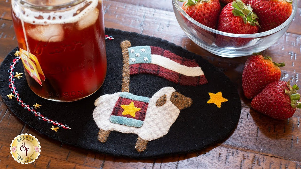 Welcome to the Wooly Mug Mat Series July tutorial! This month features a fluffy sheep, an American flag, stars, and some fun new decorative stitches